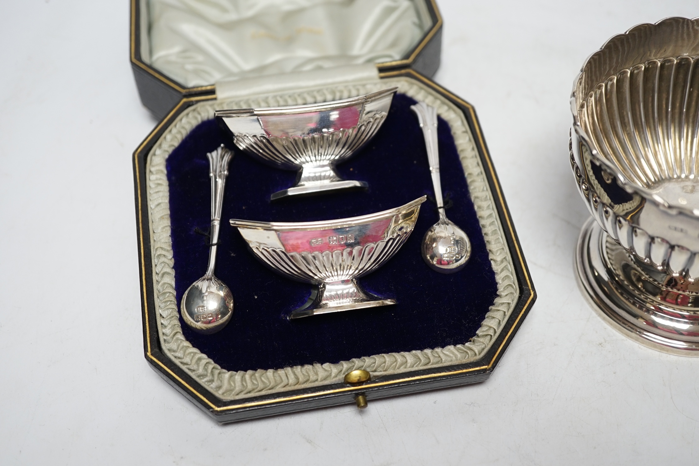 An Edwardian small silver pedestal bowl, Birmingham, 1903, diameter 10.5cm and a cased pair of George V silver salts and spoons. Fair condition.